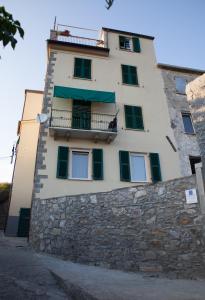 ein Gebäude mit einer Steinmauer und einem Balkon in der Unterkunft Madüneta 5 Terre in Corniglia