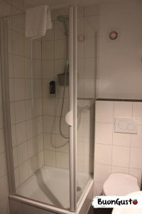 een badkamer met een douche en een toilet bij Pension BuonGusto in Steinmauern