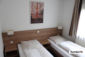 1 dormitorio con 2 camas y una foto en la pared en Pension BuonGusto, en Steinmauern