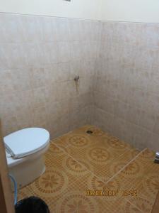 a bathroom with a toilet and a tiled floor at Salak Sunrise Homestead in Bogor