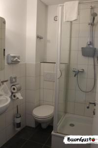 uma casa de banho com um chuveiro, um WC e um lavatório. em Pension BuonGusto em Steinmauern