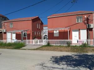 two houses with a white fence in front of them at Ammoudia Residence in Ammoudia