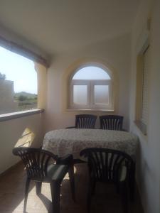 een kamer met een tafel, 2 stoelen en een raam bij Apartment Marta in Nin