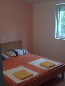 2 handdoeken op een bed in een kamer met een raam bij Apartment Marta in Nin