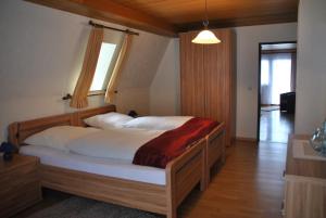ein Schlafzimmer mit einem großen Bett mit einem Holzrahmen in der Unterkunft Ferienwohnungen Haus Else in Willingen