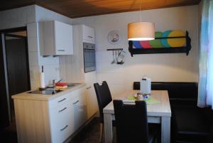 Una pequeña cocina con una mesa y un fregadero. en Ferienwohnungen Haus Else, en Willingen