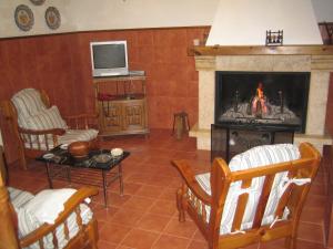 sala de estar con chimenea y TV en Casa Doña Julia en Valdealcón