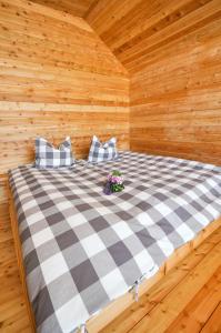 ein Bett in einer Holzhütte mit Kissen darauf in der Unterkunft Smart Wood House in Tamsweg