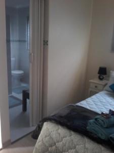 a bedroom with a bed and a bathroom with a shower at Lientjies Overnight in George