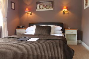 a bedroom with a large bed with two night stands at The Fairfax Arms in Gilling East