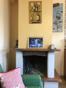 a fireplace in a living room with a green couch at Casale dell'Arvo in Lorica