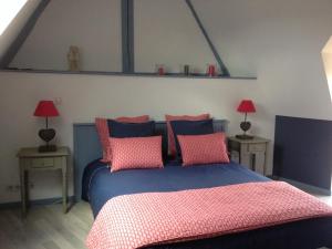 um quarto com uma cama azul e almofadas cor-de-rosa em Gite et chambre d'hôtes Du Guillot em Sainte-Solange