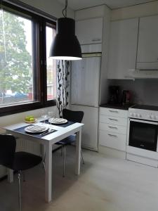 a kitchen with a table with chairs and aendant light at A lovely one-room apartment near the city centre. in Vaasa