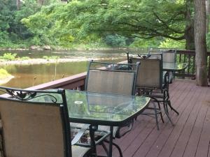 a row of tables and chairs on a deck near a river at The Landing on Shavers in Elkins