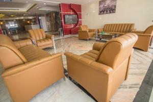 a waiting room with leather chairs and a tv at Al- Reef Hotel in Jeddah