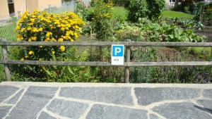 un cartel en una valla junto a un jardín con flores en Montanara, en Meiringen