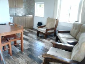 a living room with a couch and chairs and a table at Noirin's Holiday Homes in Falcarragh