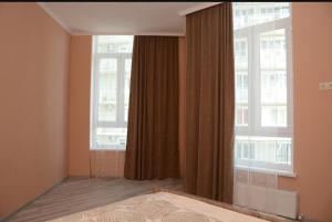 a bedroom with a bed and a large window at G.M.M Apartaments in Batumi