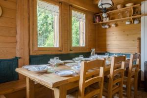 a wooden table in a wooden cabin with a dining room at Chalet Ferme des Amis in Les Gets