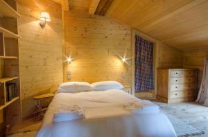 レ・ジェにあるChalet Ferme des Amisの木製の部屋にベッド1台が備わるベッドルーム1室があります。