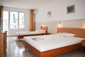 a hotel room with two beds and a window at Stella di Mare Guest House in Ravda