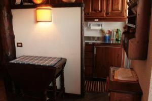 una pequeña cocina con mesa y nevera en Stile e Tradizione, en Saint Vincent