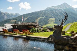 a statue of a deer on the side of a body of water at MONDI Bellevue Alm Gastein in Bad Gastein