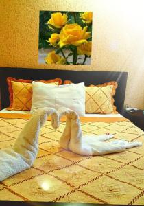 two towelsrendered to look like swans on a bed at Hotel Sali in Tbilisi City