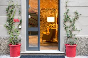 un magasin avec deux plantes en pot devant une porte dans l'établissement MaMa, à La Spezia