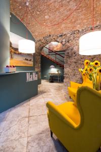 a lobby with a yellow chair and a table at MaMa in La Spezia