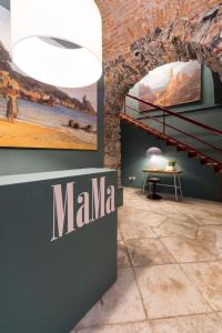 a museum with a sign on the wall and a table at MaMa in La Spezia