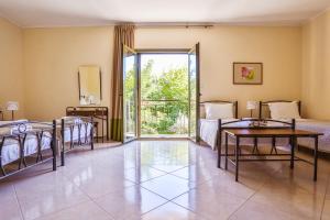 a room with beds and a room with a glass door at Hotel Marathia in Arta