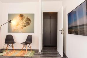 een woonkamer met 2 stoelen en een flatscreen-tv bij Studio L by MRG Apartments in Boekarest