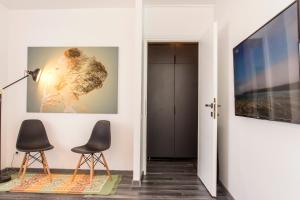 a living room with two chairs and a flat screen tv at Studio L by MRG Apartments in Bucharest