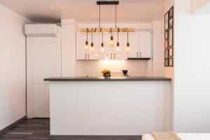 a kitchen with white cabinets and a counter top at Studio L by MRG Apartments in Bucharest