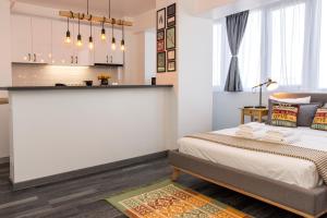 a bedroom with a bed and a kitchen at Studio L by MRG Apartments in Bucharest