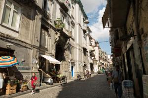 une femme marchant dans la rue avec un parapluie dans l'établissement Casa Toto', à Naples