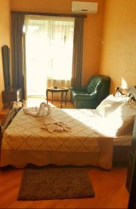 a bedroom with a bed and a chair and a window at Hotel Sali in Tbilisi City