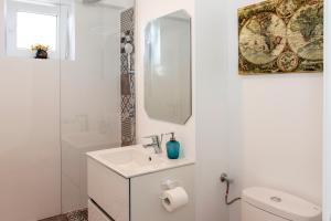a white bathroom with a sink and a mirror at Studio L by MRG Apartments in Bucharest +24 photos