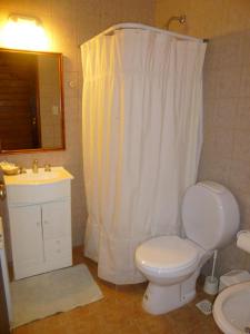 y baño con aseo blanco y lavamanos. en Hosteria Rukahué en El Calafate