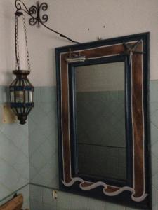 a mirror in a bathroom with a lamp and a light at La Lampara in Stromboli