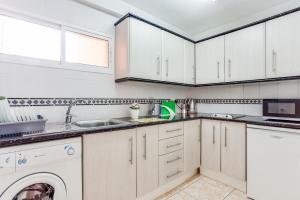 ベナルマデナにあるCorinto Apartmentのキッチン(白いキャビネット、洗濯機、乾燥機付)