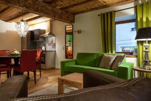 sala de estar con sofá verde y comedor en The Green House - Luxury Apartments, en St. Wolfgang