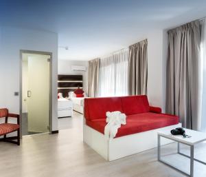 sala de estar con sofá rojo y dormitorio en Roisa Hostal Boutique, en Madrid