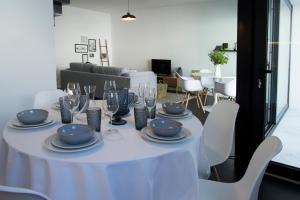 a white table with plates and wine glasses on it at Casa dos Aromas in Évora