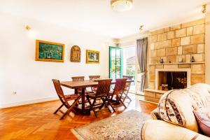 a living room with a table and chairs and a fireplace at Villa Pavlović in Herceg-Novi