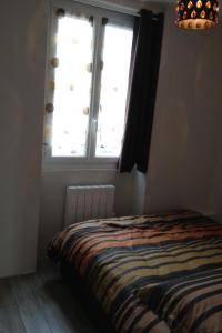 サン・テティエンヌ・ド・ティネにあるBlaise 2 piècesのベッドルーム1室(ベッド1台、窓、シャンデリア付)