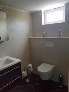 een badkamer met een wastafel, een toilet en een raam bij Spectacular Furnished Studio in Willemstad