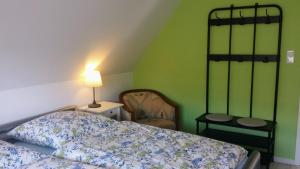 een slaapkamer met een bed, een lamp en een stoel bij Mach mal Pause bei Geni & Bernd in Kleineichen