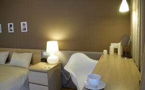 a bedroom with a bed and a table with a mirror at IRS ROYAL APARTMENTS Apartamenty IRS Fregata in Gdańsk